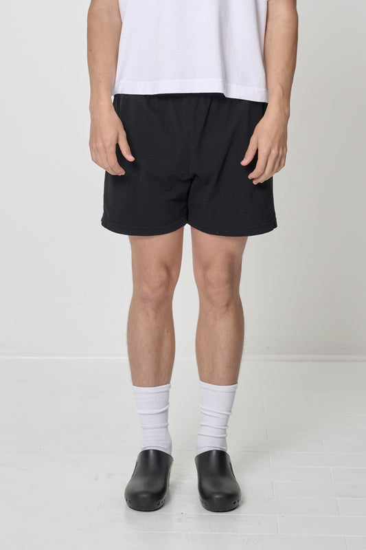 Black Everyday Shorts on model, front. Relaxed fit and mid-thigh length.