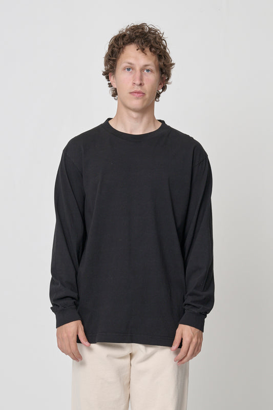6' man in size L Black Long Sleeve Boxier Trash Tee; shirt hem just below the hip, arms at his sides.