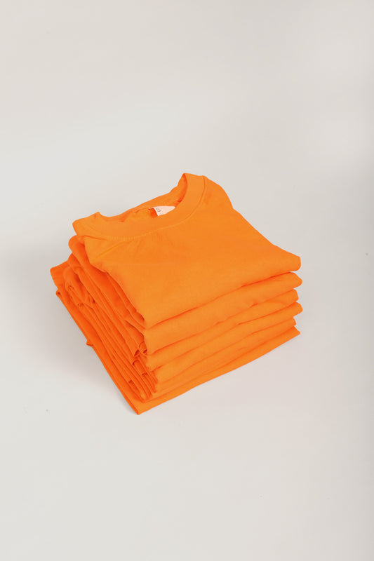Stack of Orange Short Sleeve Trash Tees