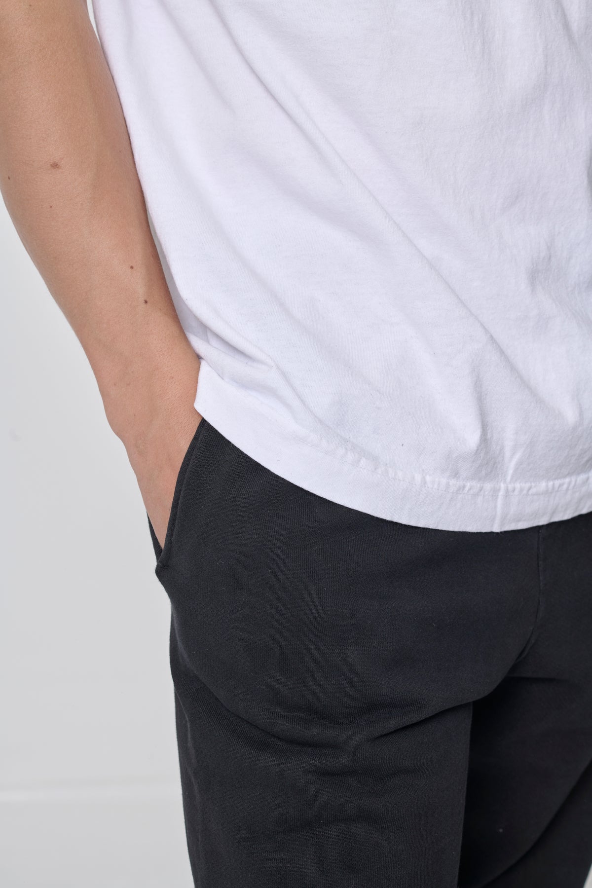 Close up: a man's right hip to featurthe shirt hem stitching.