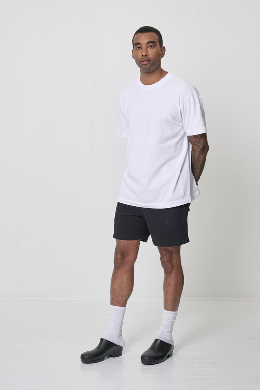 Man in a White Short Sleeve Trash Tee facing 45-degrees from the front, showing relaxed short sleeves.