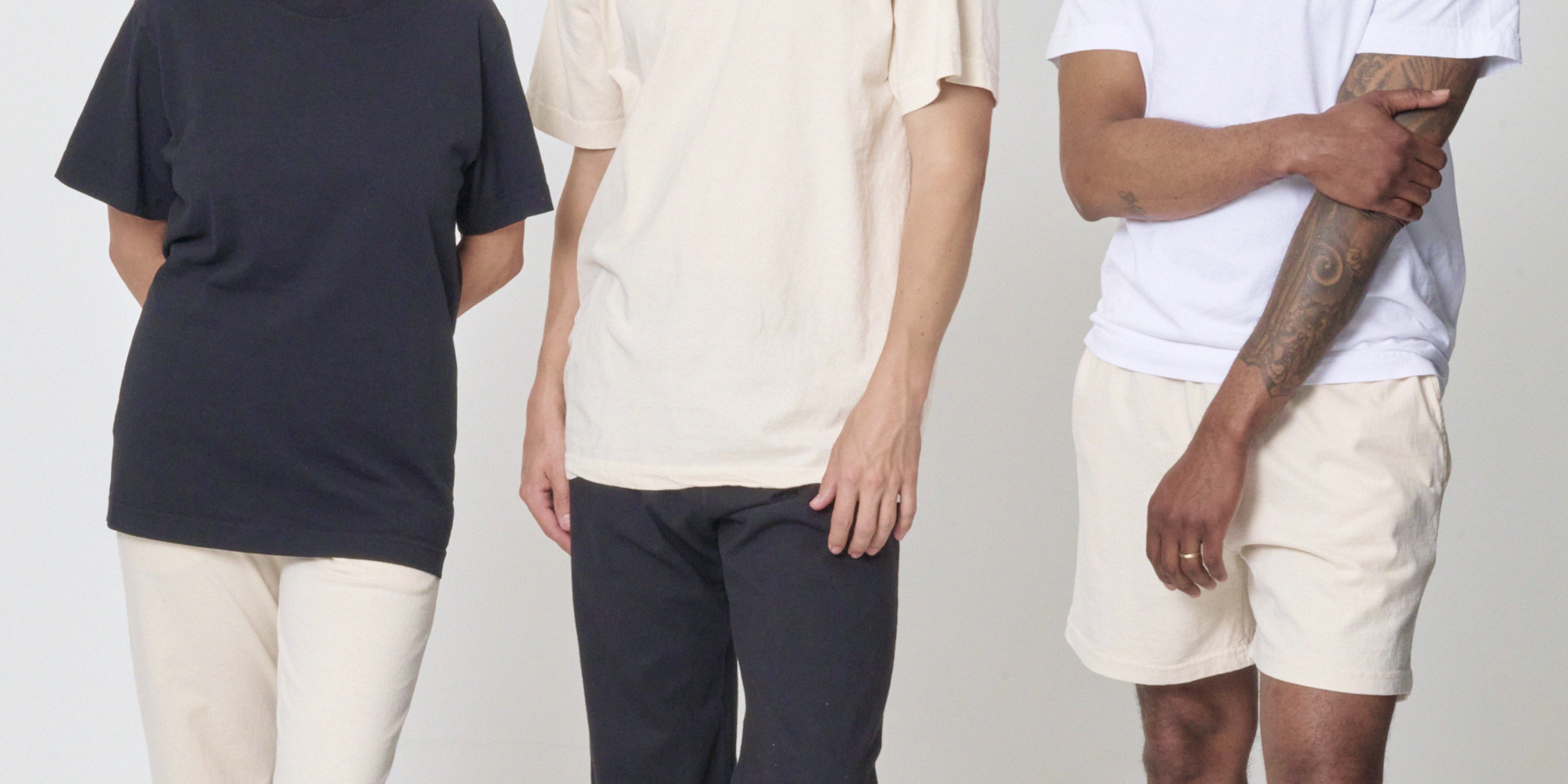 Three people, clad in White, Scour, and Black styles from the Trash Collection, depicted from the shoulders to the knees.