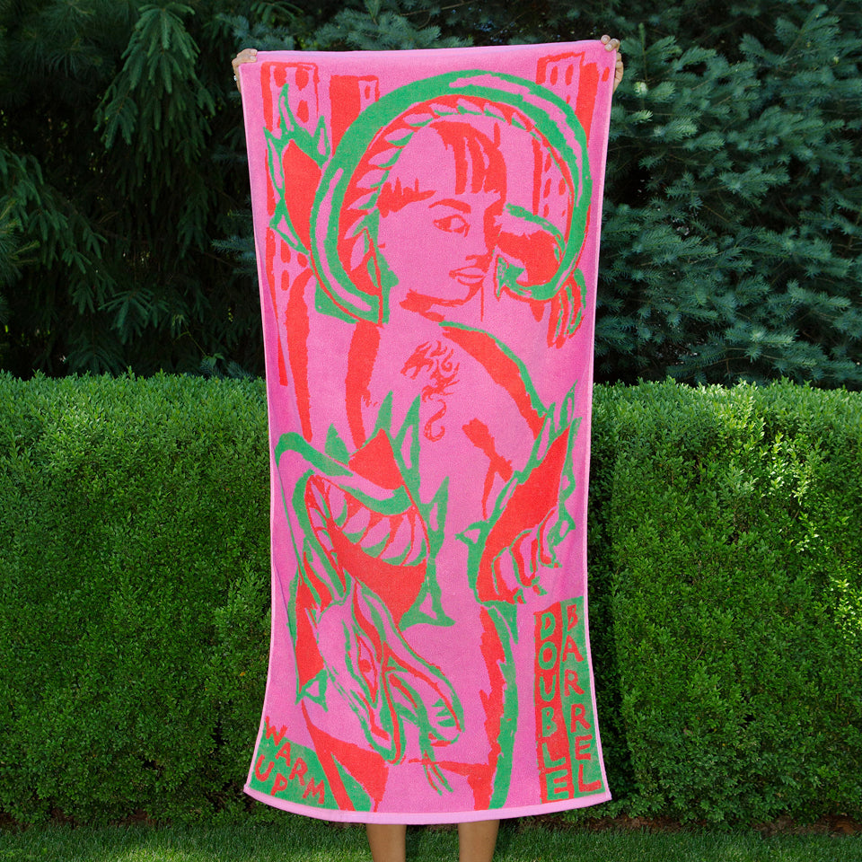 Custom Towel with pink and green abstract design of a person held up by someone behind the towel with green bush background