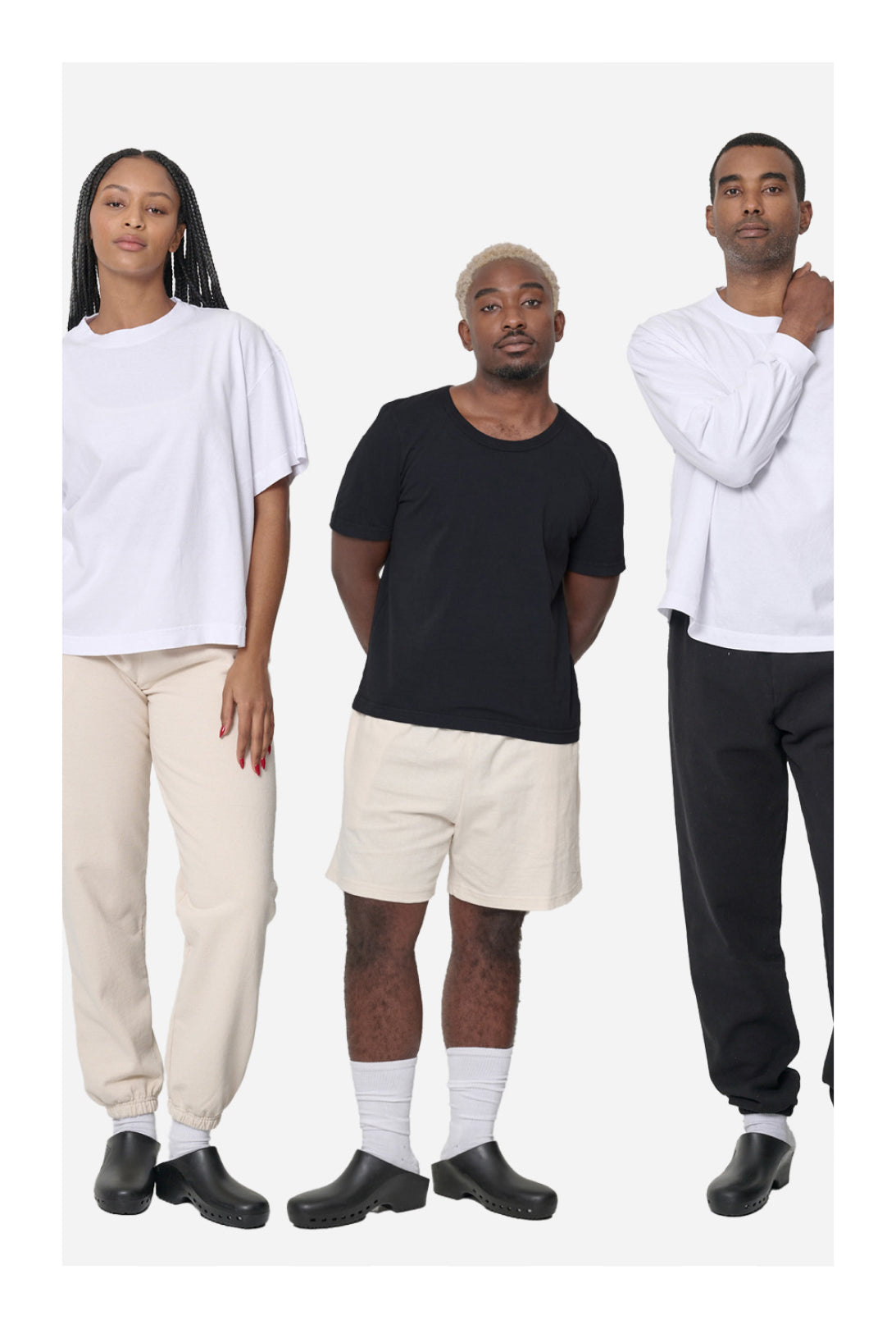 Three people wearing a variety of Everybody.World wholesale garments in Scour, White, and Black on a white background