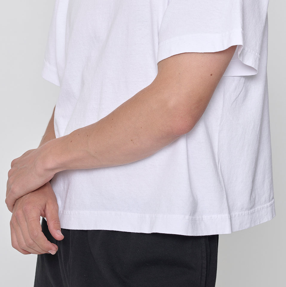 Close up of torso of a person wearing a Boxier Trash Tee in White and Trash Sweatpants in Black.