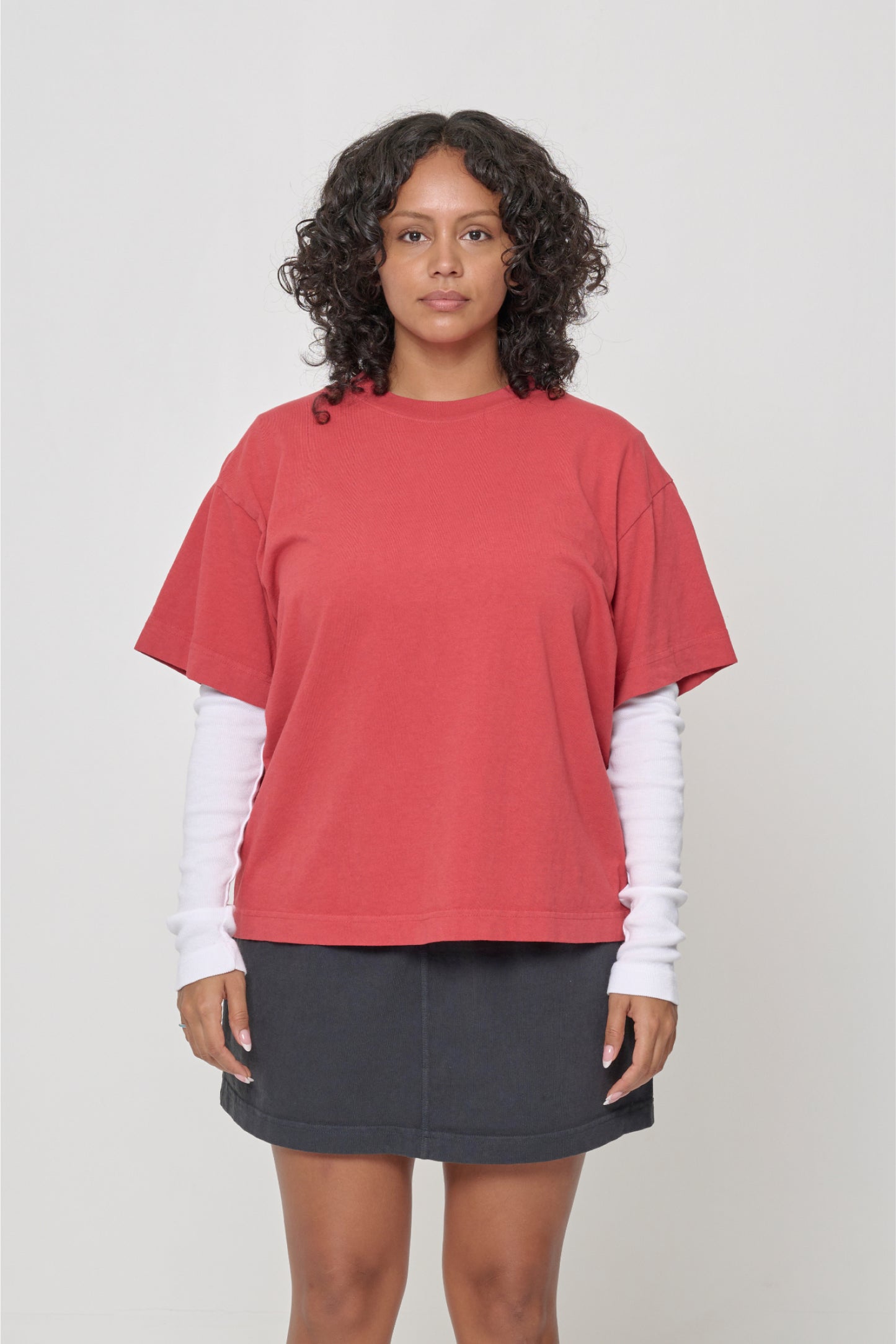 5'7" woman in a size M Cedar Boxier Trash Tee. Hem at her lower middle hip.