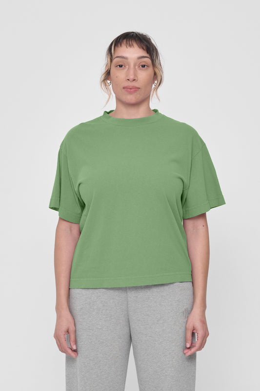 A woman in a Fox Green Boxier Trash Tee. Hem ends just above the hip.