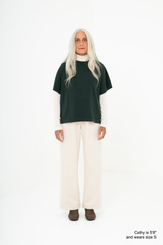 Model wearing a green shirt and scour pants