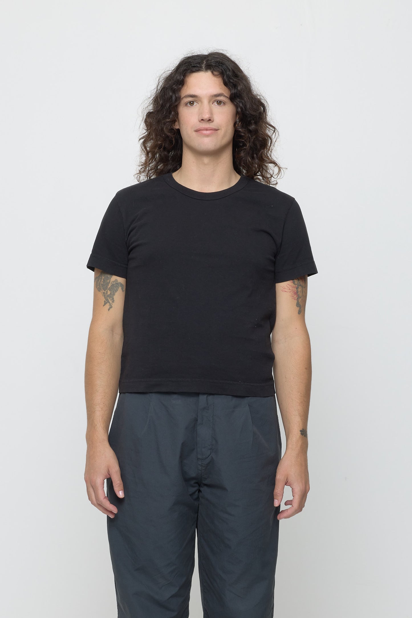 6' person in a Black Tailored Trash Tee in Size M. Shirt hem hits their upper hip.