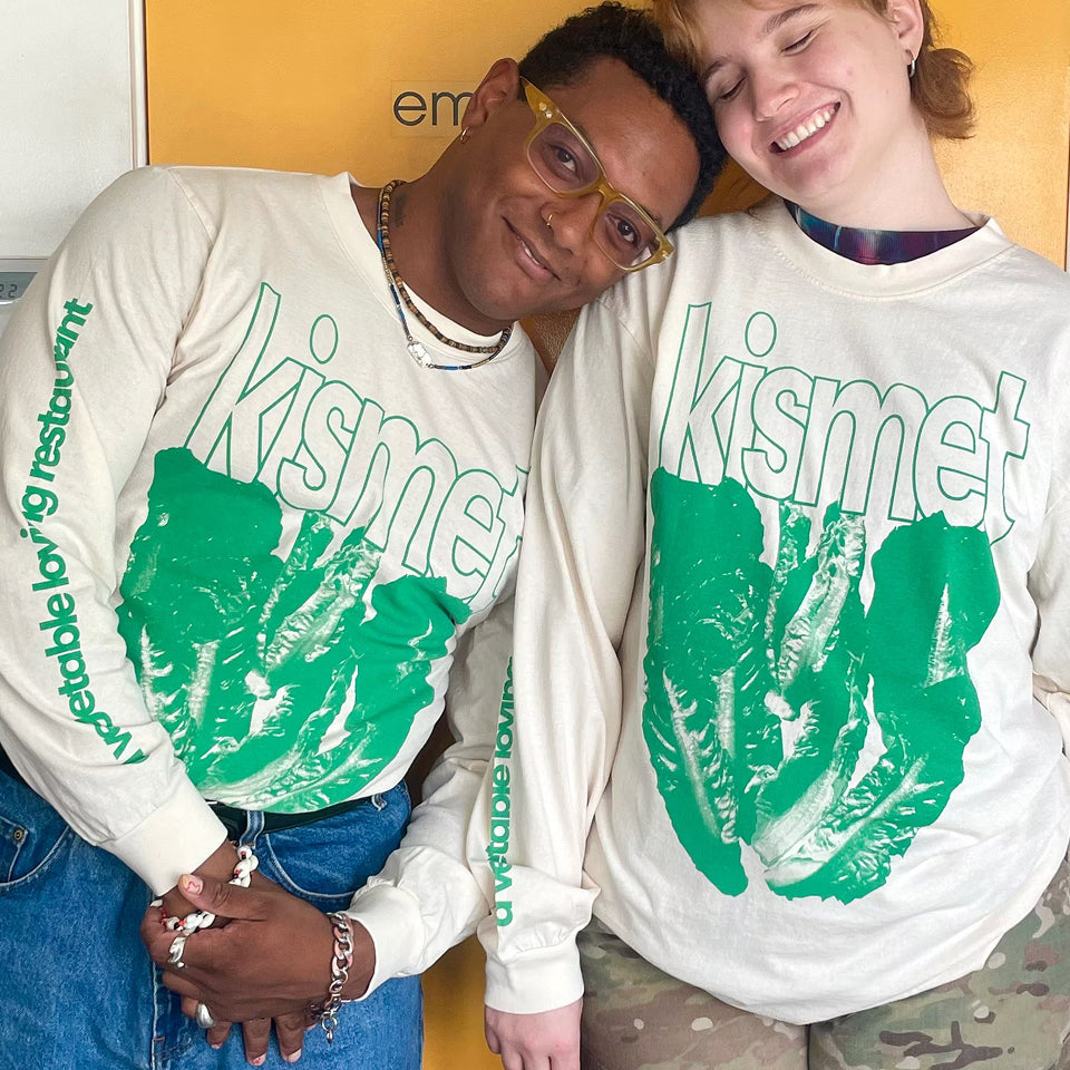 Two people wearing matching custom Long Sleeve Trash Tees with 'kismet' text and green lettuce graphic design.